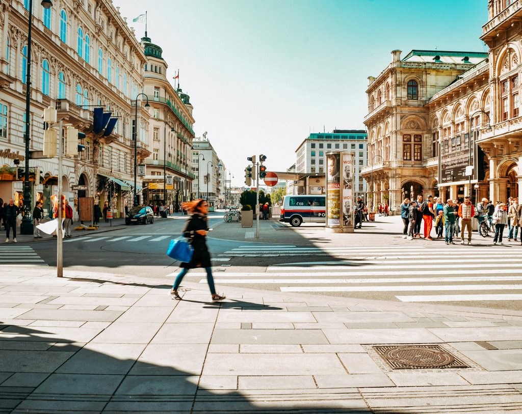 Young woman walking along a cobblestone street in a historic European city centre